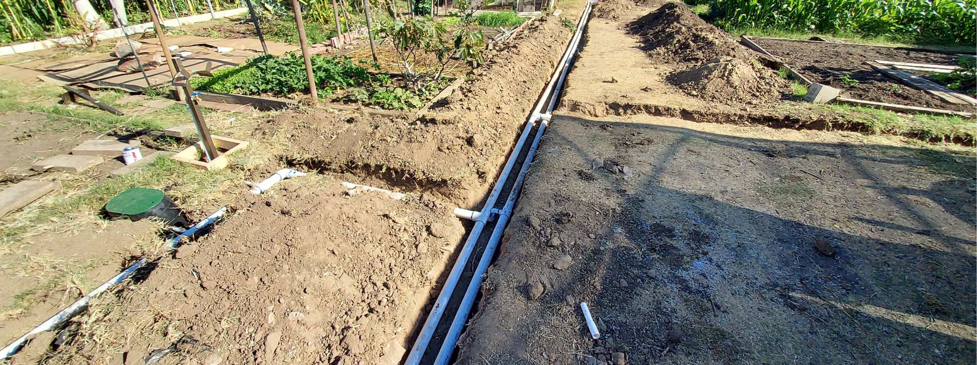 Parallel PVC water lines laid out in a garden trench for a comprehensive landscape development and irrigation project in Southern California.