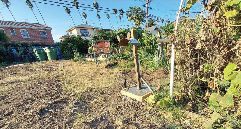 Close-up of a newly installed outdoor water spigot with a concrete footing as part of a community garden irrigation project.